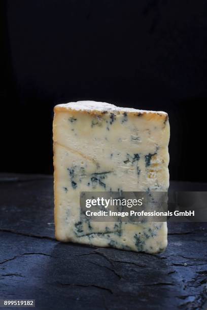 a wedge of stilton on a slate board - cheese wedge foto e immagini stock