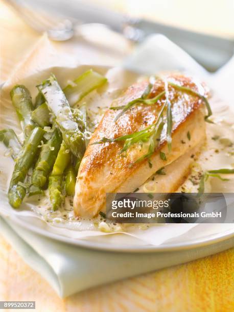 chicken breast and green asparagus cooked in wax paper with foamy tarragon and citronella sauce - asparagina foto e immagini stock