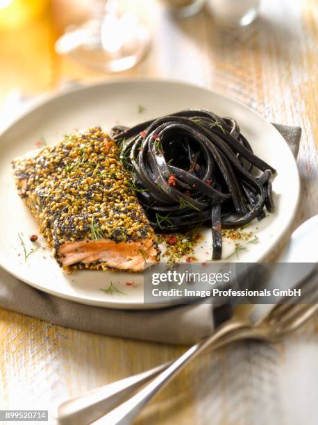 salmon steak in sesame and poppy seed crust,squid ink spaghettis - squid ink pasta stock pictures, royalty-free photos & images