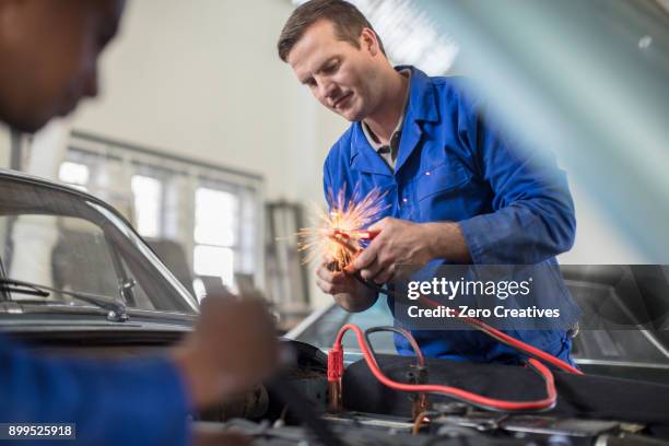 car mechanics testing car engine in repair garage - car battery stock pictures, royalty-free photos & images