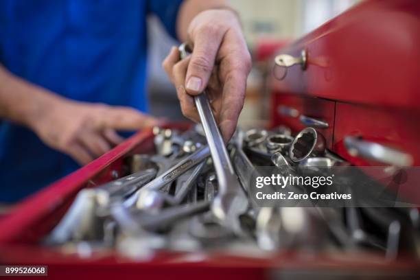 hands of male car mechanic selecting wrench from tool box in repair garage - toolbox - fotografias e filmes do acervo