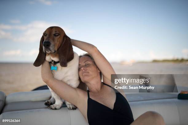 woman and pet dog relaxing on boat - joined at hip stock pictures, royalty-free photos & images