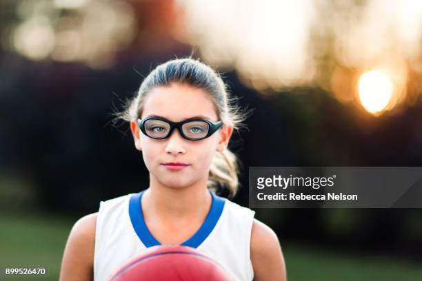 portrait of girl wearing sports goggles holding basketball - lunettes de pilote de course photos et images de collection