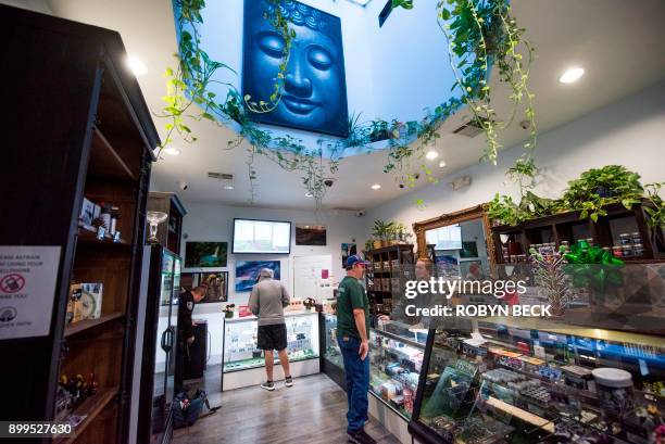 Budtender assists a customer at the Higher Path medical marijuana dispensary in the San Fernando Valley area of Los Angeles, California, December 27,...