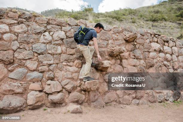 man exploring moray ruins in maras, cusco, peru, south america - moray cusco fotografías e imágenes de stock