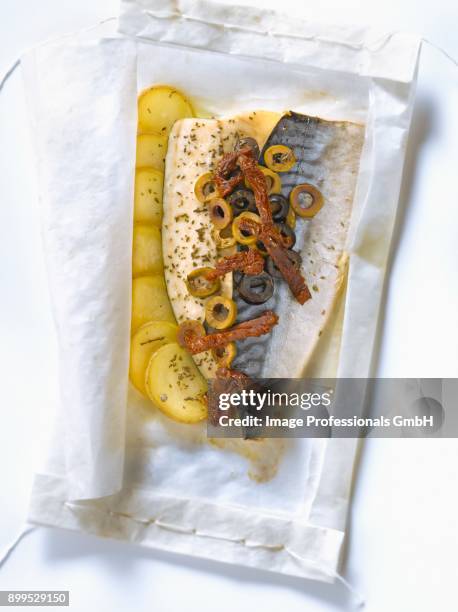 mackerel with green and black olives,sun-dried tomatoes and zucchinis cooked in wax paper - zucchine stock pictures, royalty-free photos & images