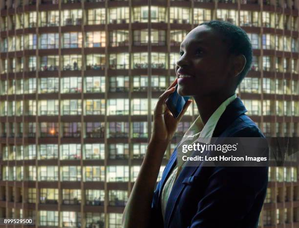 businesswoman using phone, facade of neighbouring building in background - kenya business stock pictures, royalty-free photos & images