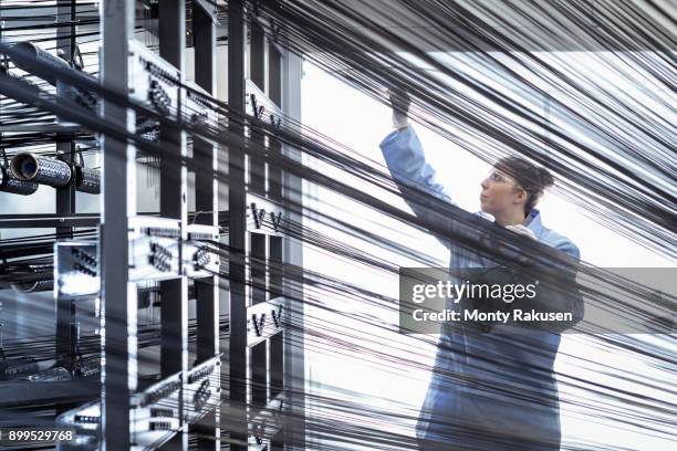 female operator with carbon fibre thread on loom in carbon fibre production facility - carbon fibre stockfoto's en -beelden