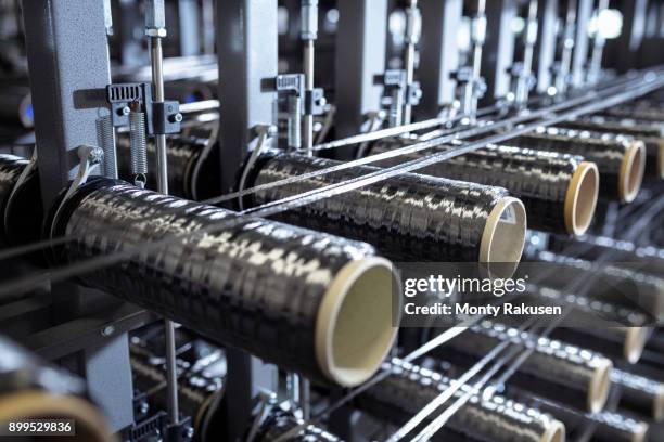 carbon fibre bobbins on loom in carbon fibre production facility - carbon fibre stock pictures, royalty-free photos & images