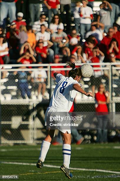female soccer player heads ball with spectators and copy space - heading the ball stockfoto's en -beelden