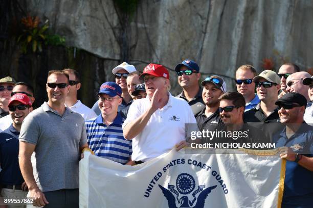 President Donald Trump holds the flag of the United States Coast Guard while speaking to service members of the Coast Guard during an invitation to...