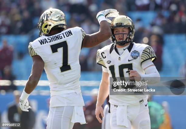 Teammates John Wolford and Scotty Washington of the Wake Forest Demon Deacons celebrate after a touchdown against the Texas A&M Aggies during the...