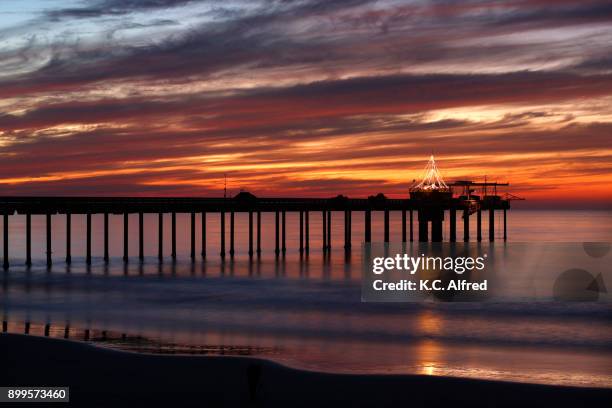 the sun sets on the pacific ocean at the scripps institute of oceanography pier in the la jolla area of san diego, california. - scripps pier stock pictures, royalty-free photos & images