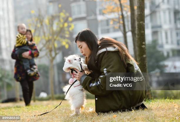 Yu Linghan plays with her dog Xiao Qi at a park on December 23, 2017 in Chengdu, Sichuan Province of China. 20-year-old Chinese girl Yu Linghan...