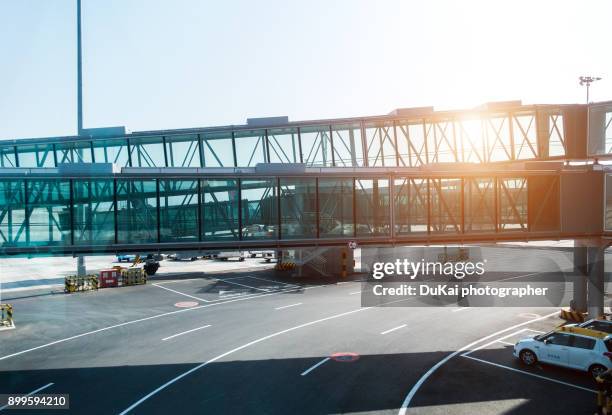 airport covered bridges - flugzeug sonne stock-fotos und bilder