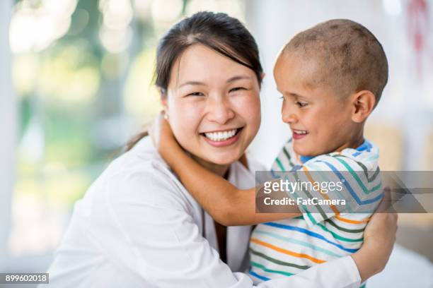 hugging his doctor - childhood cancer stock pictures, royalty-free photos & images