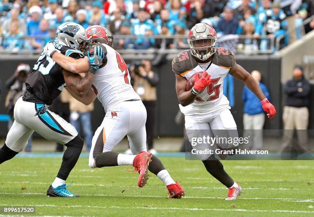 Peyton Barber of the Tampa Bay Buccaneers rus against the Carolina Panthers during their game at Bank of America Stadium on December 24, 2017 in...