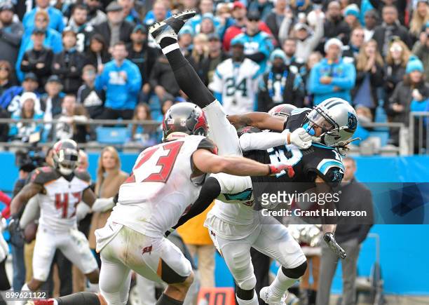 Chris Conte of the Tampa Bay Buccaneers upends Kaelin Clay of the Carolina Panthers during their game at Bank of America Stadium on December 24, 2017...