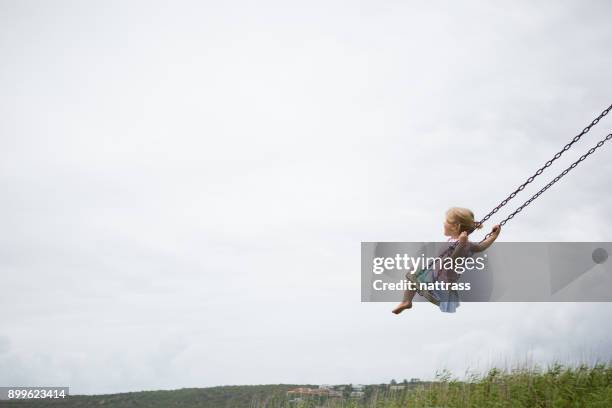 kleines kind schwingt auf einer holzschaukel - schaukel stock-fotos und bilder