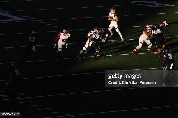 Quarterback Tyler Rogers of the New Mexico State Aggies drops back to pass during the first half of the Nova Home Loans Arizona Bowl game against the...