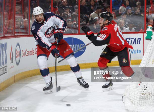 Seth Jones of the Columbus Blue Jackets passes the puck as Ryan Dzingel of the Ottawa Senators pressures on the forecheck at Canadian Tire Centre on...