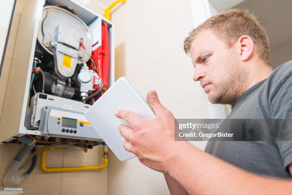 Technician repairing Gas Furnace using digital tablet