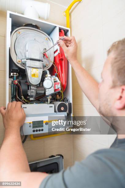 technician repairing gas furnace - gas appliances stock pictures, royalty-free photos & images