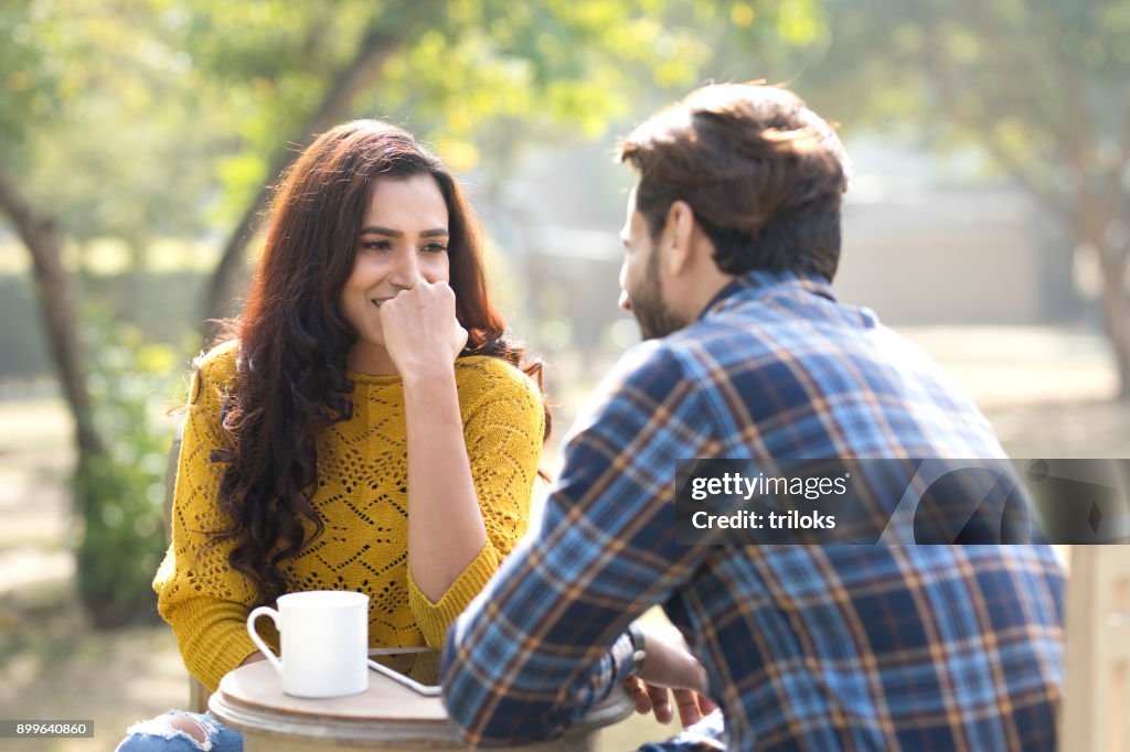 Casal indiano romântico tomando café no parque