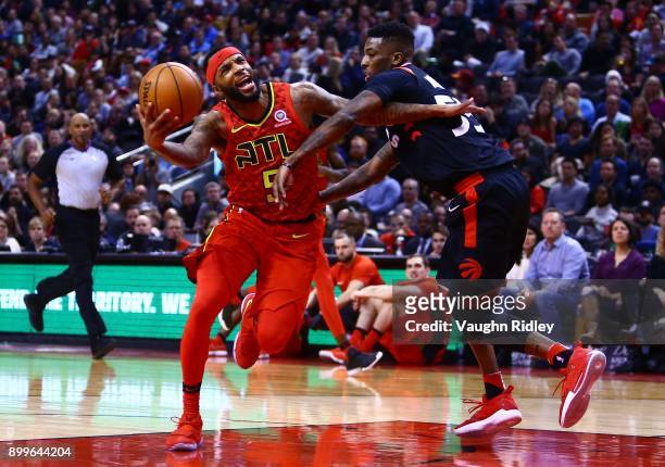 Malcolm Delaney of the Atlanta Hawks dribbles the ball as Delon Wright of the Toronto Raptors defends during the second half of an NBA game at Air...