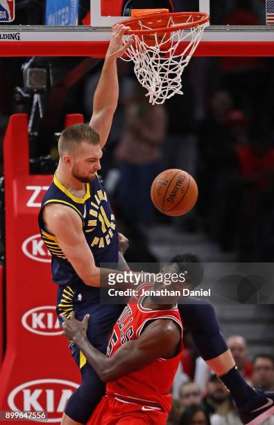 Domantas Sabonis of the Indiana Pacers dunks over Bobby Portis of the Chicago Bulls at the United Center on December 29, 2017 in Chicago, Illinois....