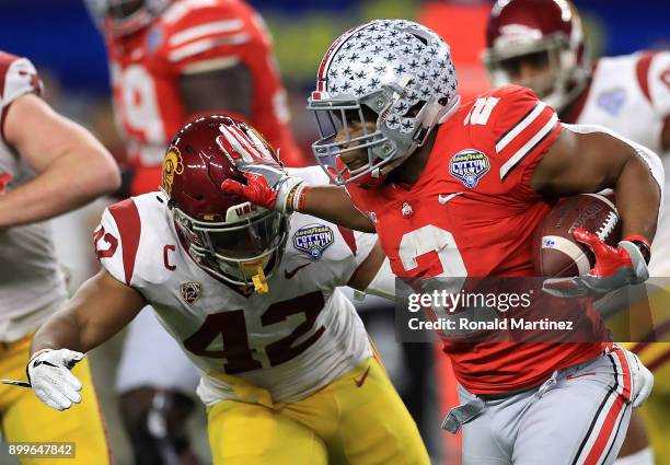 Dobbins of the Ohio State Buckeyes runs the ball past Uchenna Nwosu of the USC Trojans in the second quarter during the Goodyear Cotton Bowl at AT&T...