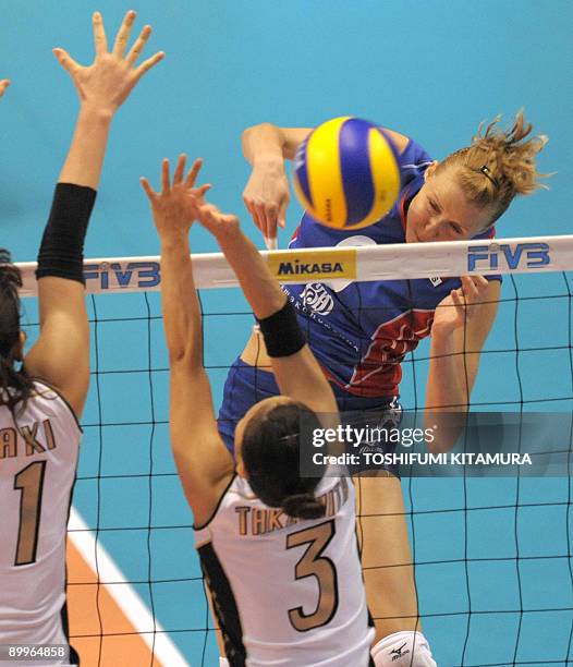 Russia's Olga Fateeva spikes the ball past Japan's captain Erika Araki and setter Yoshie Takeshita during their 2009 FIVB World Grand Prix women's...