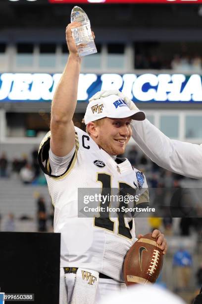 Wake Forest Demon Deacons quarterback John Wolford is awarded the Jerry Richardson MVP trophy after winning the Belk Bowl between the Wake Forest...