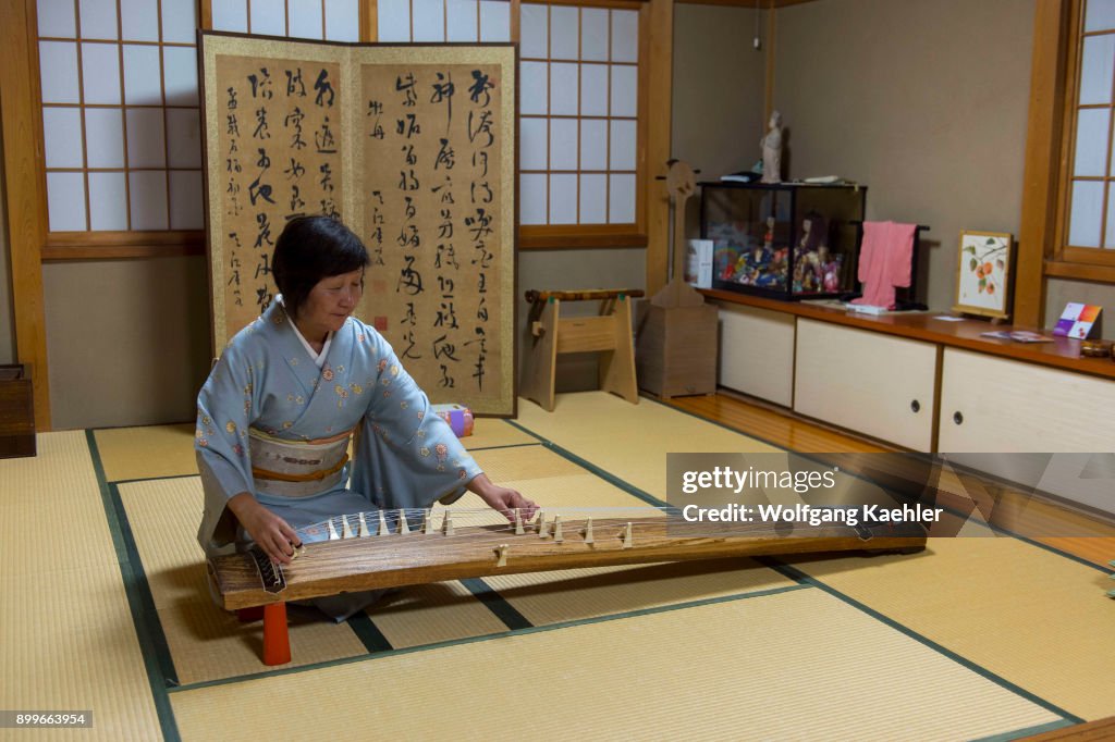 A Japanese woman in a kimono in Kyoto, Japan, is playing the...