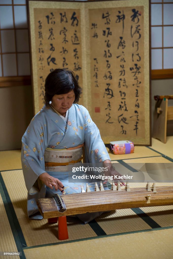 A Japanese woman in a kimono in Kyoto, Japan, is playing the...