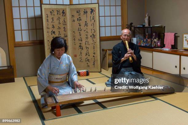 Japanese couple in traditional clothing in Kyoto, Japan, is playing the koto, a traditional Japanese stringed musical instrument and the shakuhachi...