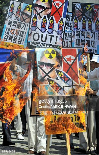 South Korean conservative activists burn placards showing pictures of North Korean leader Kim Jong-Il during an anti-North Korea rally in Seoul on...