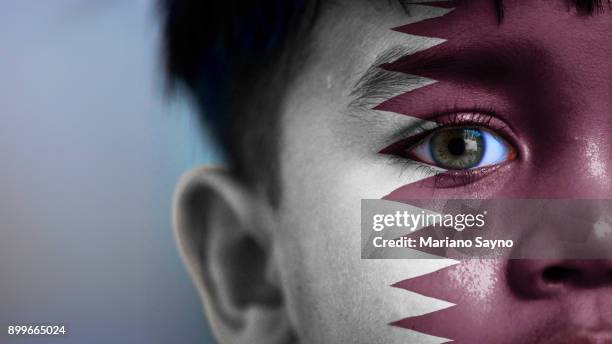 boy's face, looking at camera, cropped view with digitally placed qatar flag on his face. - body paint 個照片及圖片檔