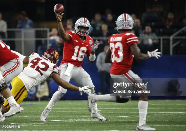 Barrett of the Ohio State Buckeyes throws while under pressure from Uchenna Nwosu of the USC Trojans in the second half of the 82nd Goodyear Cotton...