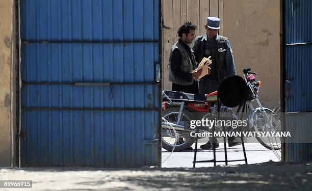 An Afghan National Police officer searches a passerby outside a polling centre at Baraki Barak district in Logar Province on August 20, 2009. Afghans...