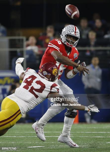 Barrett of the Ohio State Buckeyes throws while under pressure from Uchenna Nwosu of the USC Trojans in the second half of the 82nd Goodyear Cotton...