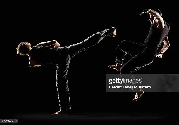 fighter striking opponent with spinning back kick - martial arts stock pictures, royalty-free photos & images