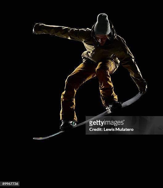snowboarder pulling front nose grab mid air - snowboarder stock pictures, royalty-free photos & images