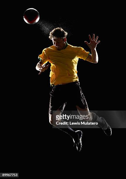 soccer player jumping in the air to head a ball - kopfball stock-fotos und bilder