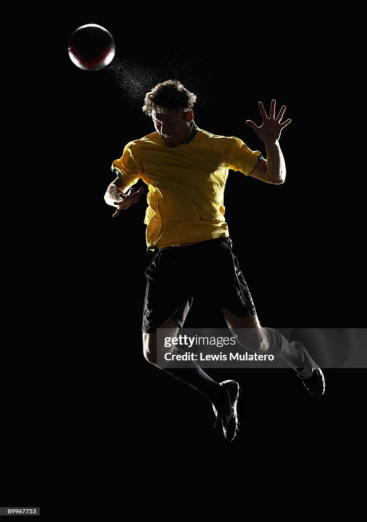 Soccer player jumping in the air to head a ball