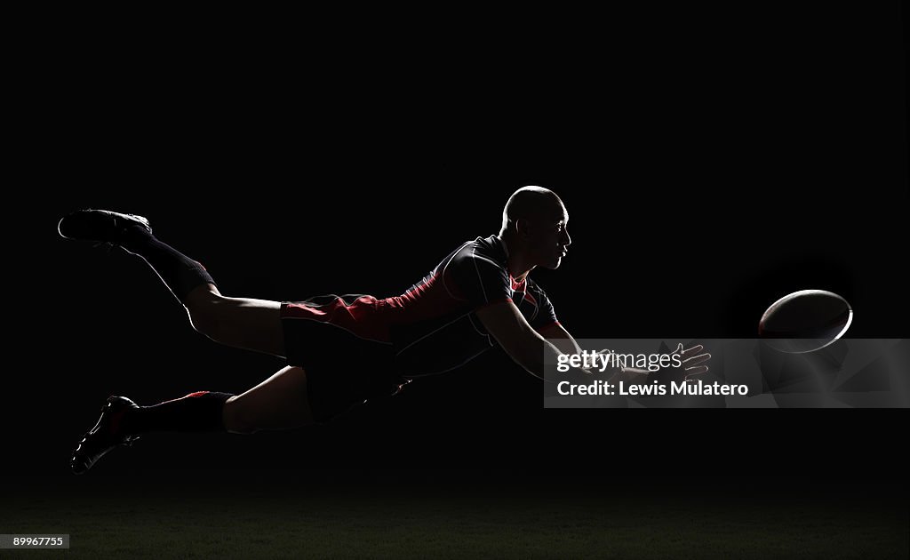 Rugby player making a diving pass of the ball