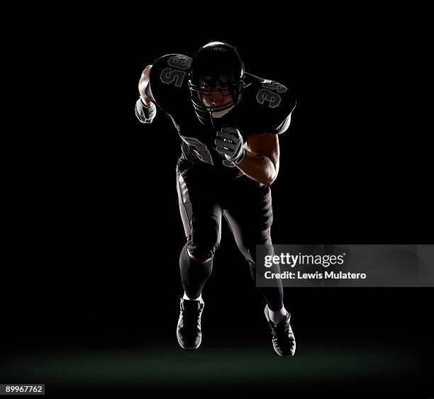 american football player running - アスリート　黒背景 ストックフォトと画像