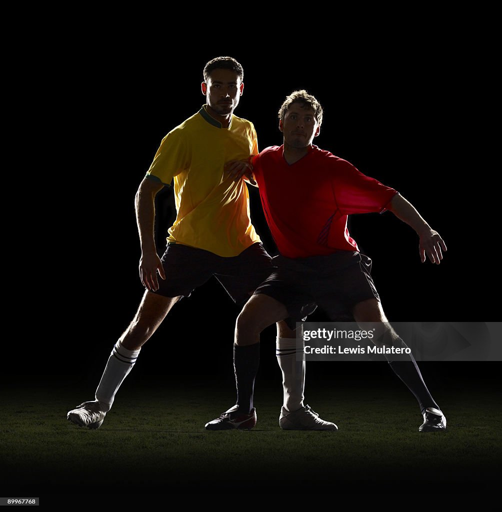 Two soccer players jostling each other