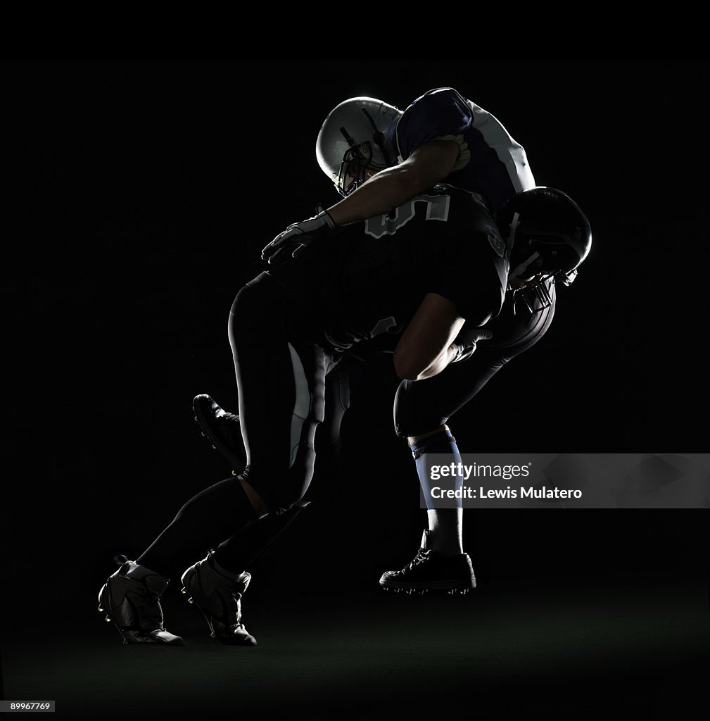 American football player tackling opponent