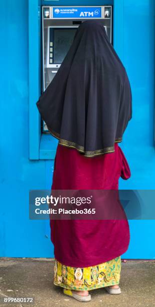 muslim woman using krungthai bank atm - thai coin stock pictures, royalty-free photos & images
